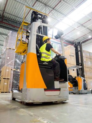 Forklift operator during work in large warehouse